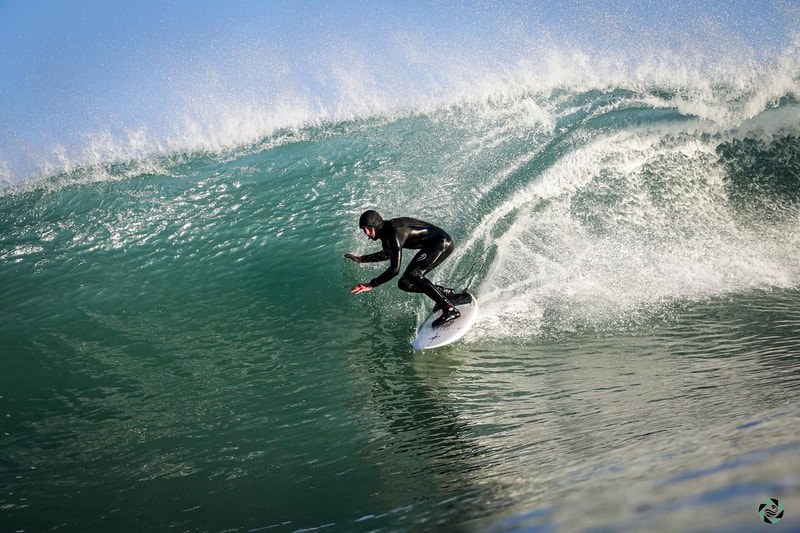 Morgan Ménez, fondateur et moniteur de l’école Surf Harmony, surfe une vague sur la plage de longchamp entre saint-briac et saint-lunaire, près de dinard et saint-malo, en bretagne.